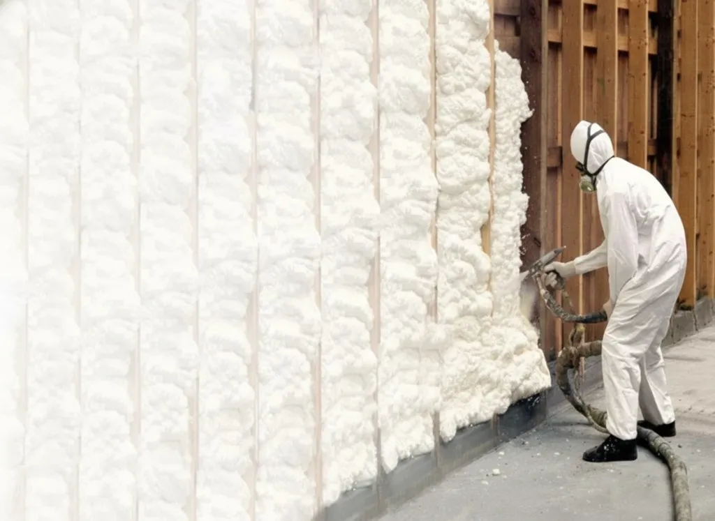 Spray foam being applied between wall studs